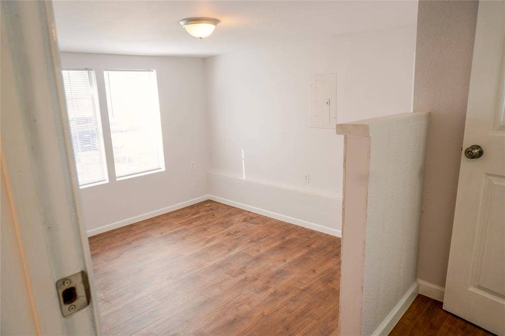 3229 Hardeman Street, Fort Worth, TX 76119 Room featuring wood-finish flooring, dual windows, and a flush-mount ceiling light fixture