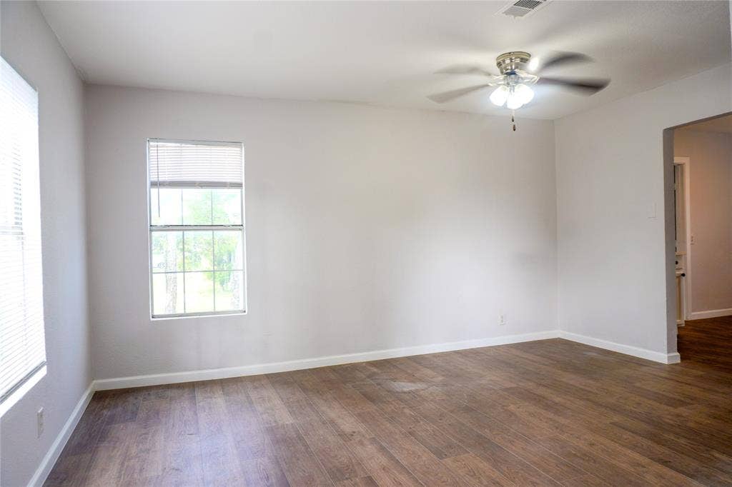 3229 Hardeman Street, Fort Worth, TX 76119 Neutral wall finishes, wood-finish flooring, and a ceiling-mounted light fixture with a fan