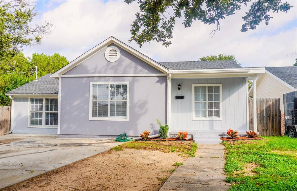 3229 Hardeman Street, Fort Worth, TX 76119 Single-story exterior featuring light-colored siding, a gabled roofline, grid-pattern windows, and a paved walkway leading to the front entryway