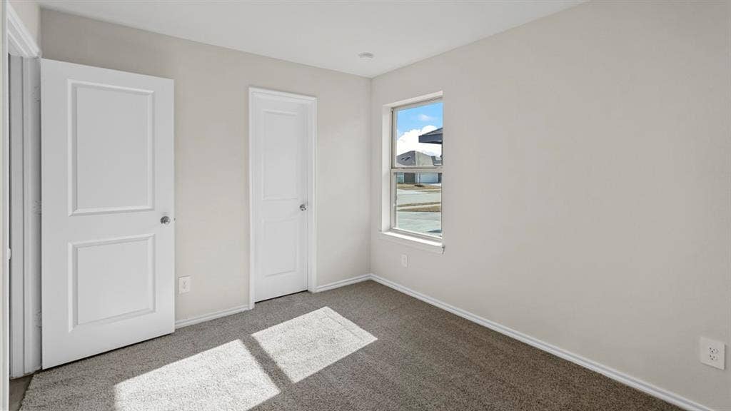 617 Dunham Road, Nevada, TX 75173 Light gray wall finish, white trim, gray carpet flooring, white paneled doors, and a double-hung window