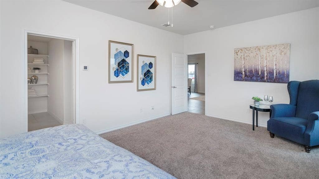 406 Campfield Drive, Caddo Mills, TX 75135 Spacious room with plush carpet flooring, a ceiling fan with integrated lighting, and a walk-in closet featuring built-in shelving
