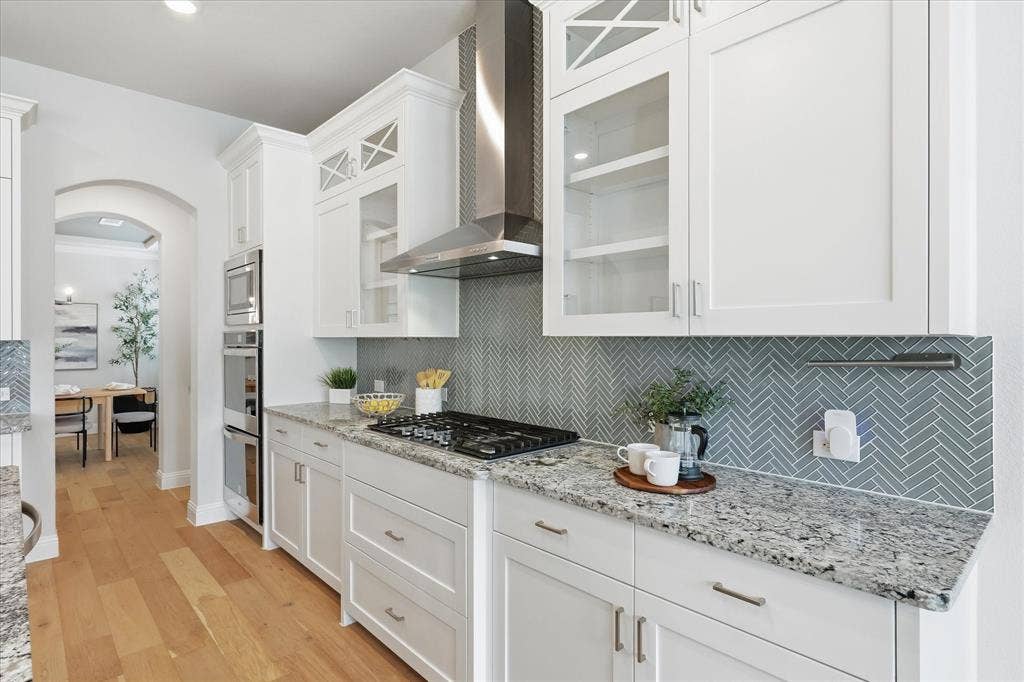 Crisp white ceiling-height cabinets, double ovens, a gas stove, and a walk-in pantry make this bright kitchen and breakfast nook the ultimate space to cook and entertain!