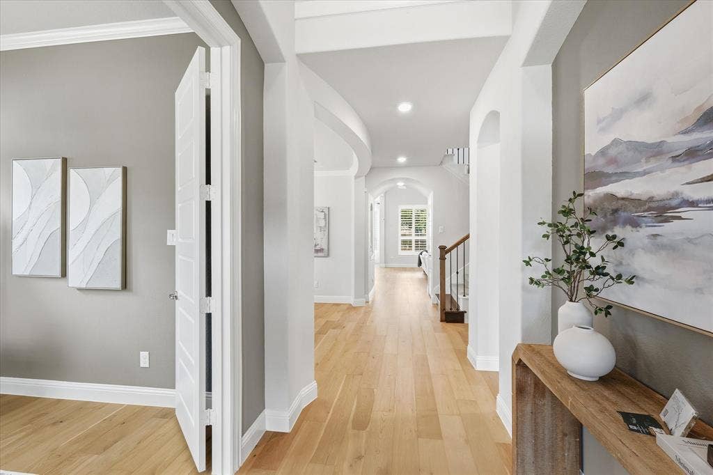 Elongated foyer that flows into the home office with French doors.