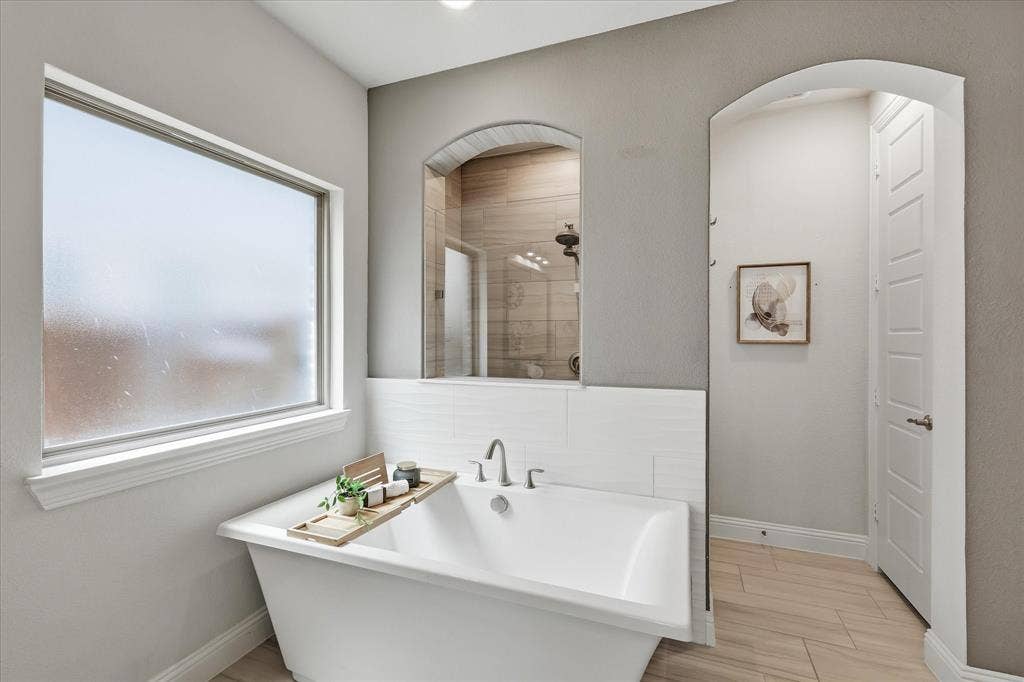 Freestanding white soaking tub and walk in shower. A true spa!