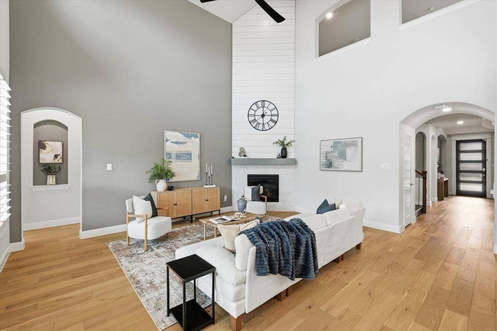 The floor-to-ceiling fireplace serves as a striking anchor, making this versatile space perfect for both large gatherings and everyday relaxation.