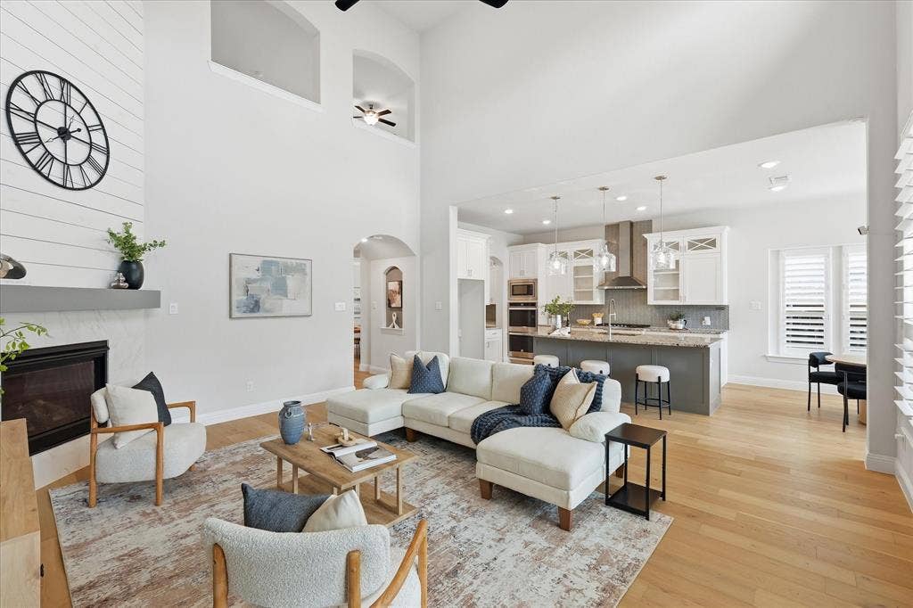 Double-height ceilings create an airy, grand feel in this main living space that flows effortlessly into the kitchen.