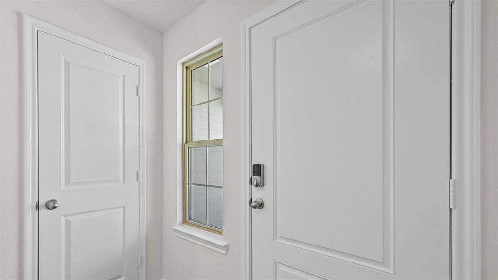 Panel doors with white trim, a window with gridded panes, and a keyless entry system