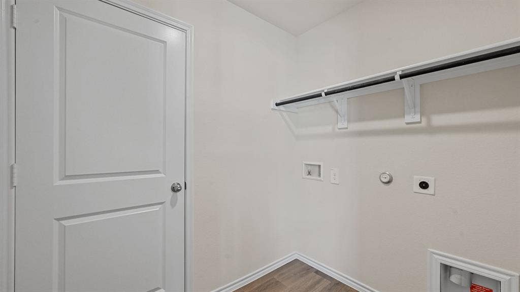 White paneled door, wood-finish flooring, and a mounted shelf and clothing rod
