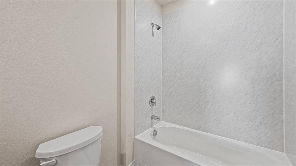 White porcelain bathtub with a coordinating shower surround and chrome fixtures