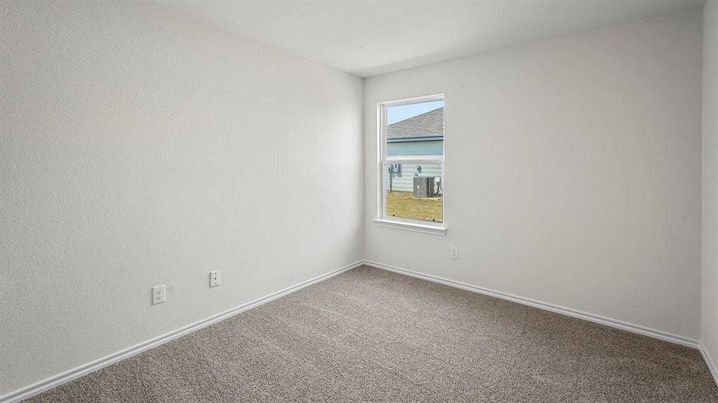 Neutral interior room featuring textured walls, neutral carpeting, and a single-pane window