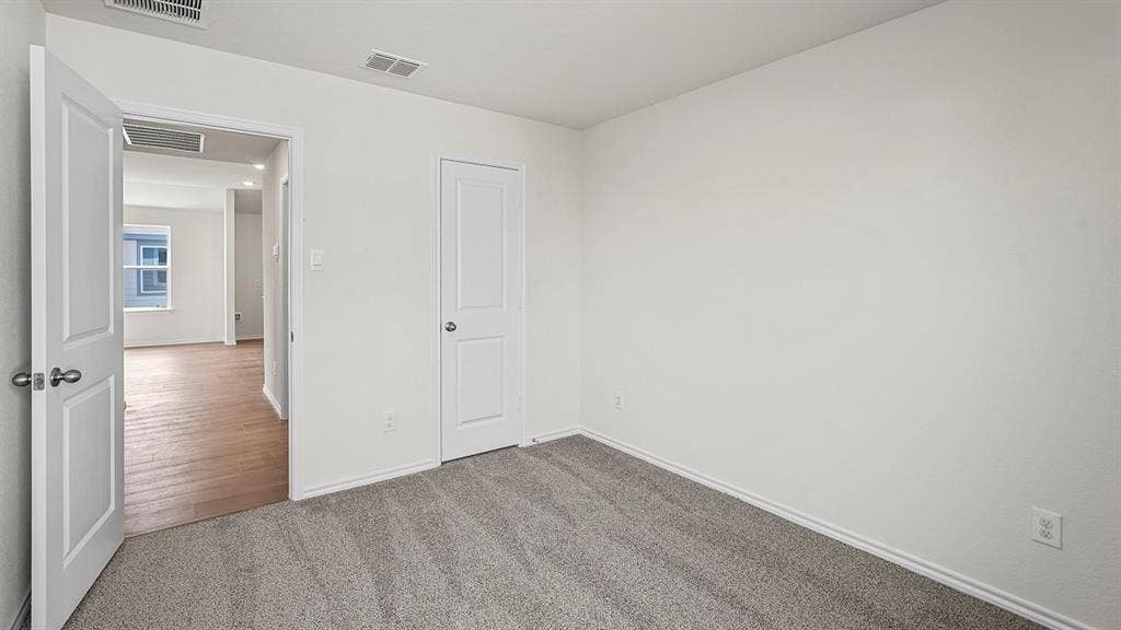 Neutral-toned wall-to-wall carpeting, solid-core two-panel interior doors with brushed nickel hardware, and smooth-finish drywall
