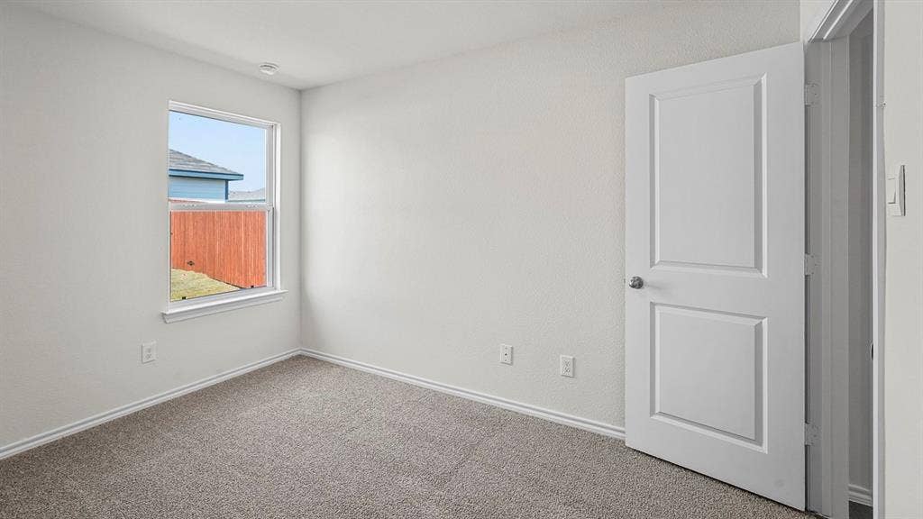 Neutral-toned wall paint, neutral carpeting, single-hung window, and a multi-panel interior door