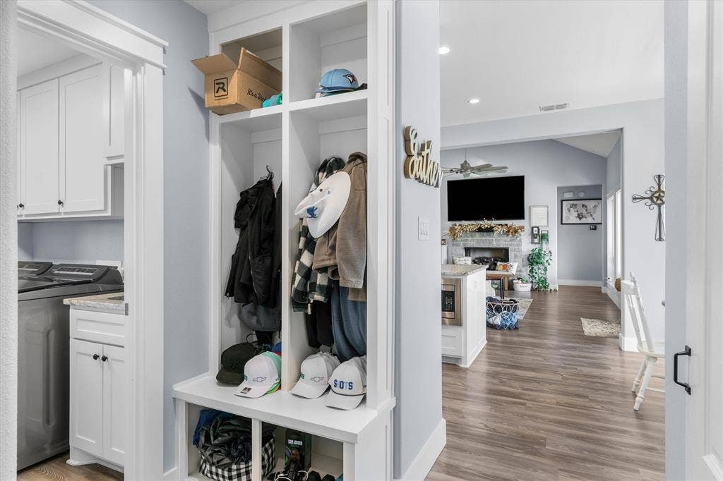 203 Splitrail Drive, Mabank, TX 75143 Custom built-in mudroom locker unit with shelving and bench seating, white cabinetry, wood-finish flooring, and recessed ceiling lighting