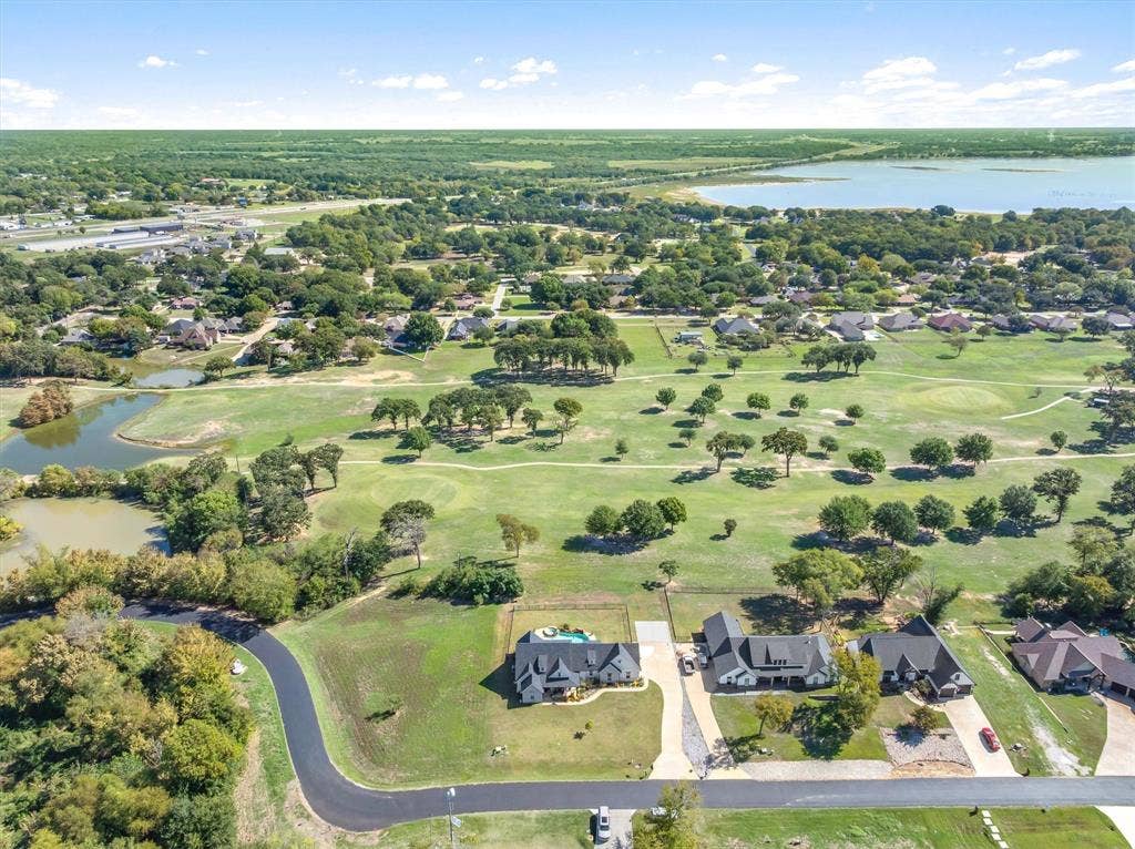 203 Splitrail Drive, Mabank, TX 75143 Aerial perspective featuring expansive acreage, a private swimming pool, mature tree canopy, and proximity to a lake and golf course
