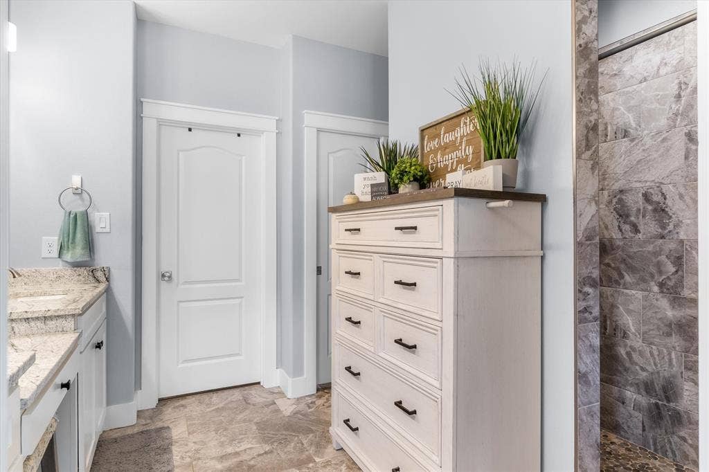 203 Splitrail Drive, Mabank, TX 75143 Stone tile flooring, vanity with stone countertop, and tiled shower enclosure