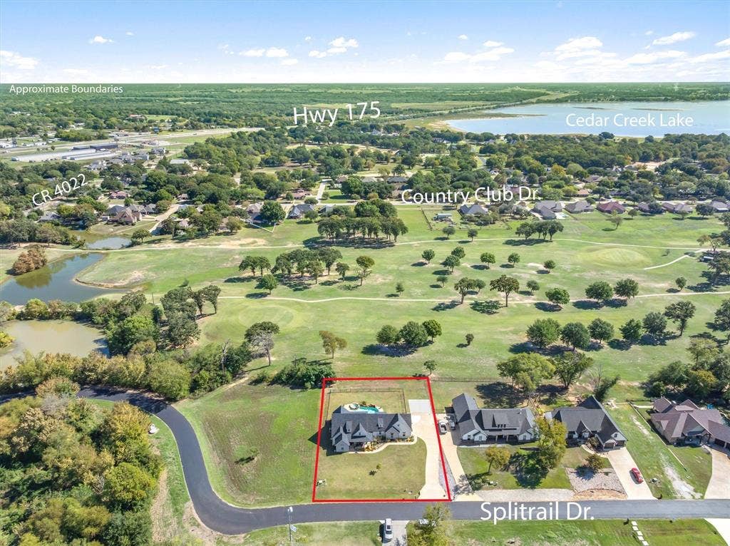 203 Splitrail Drive, Mabank, TX 75143 Aerial view of property situated on a corner lot featuring a rear in-ground swimming pool, direct proximity to a golf course, and mature tree-lined surroundings