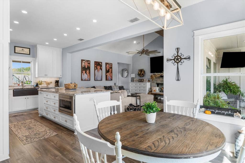 203 Splitrail Drive, Mabank, TX 75143 Kitchen featuring white cabinetry, a center island with integrated microwave, farmhouse sink, recessed lighting, and wood-finish flooring