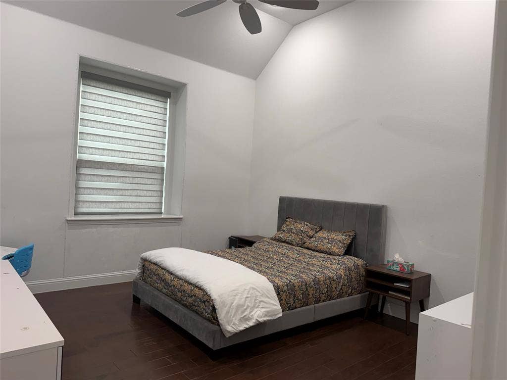 Open-concept living space featuring wood-finish flooring, tray ceilings, recessed lighting, and a tiered crystal chandelier