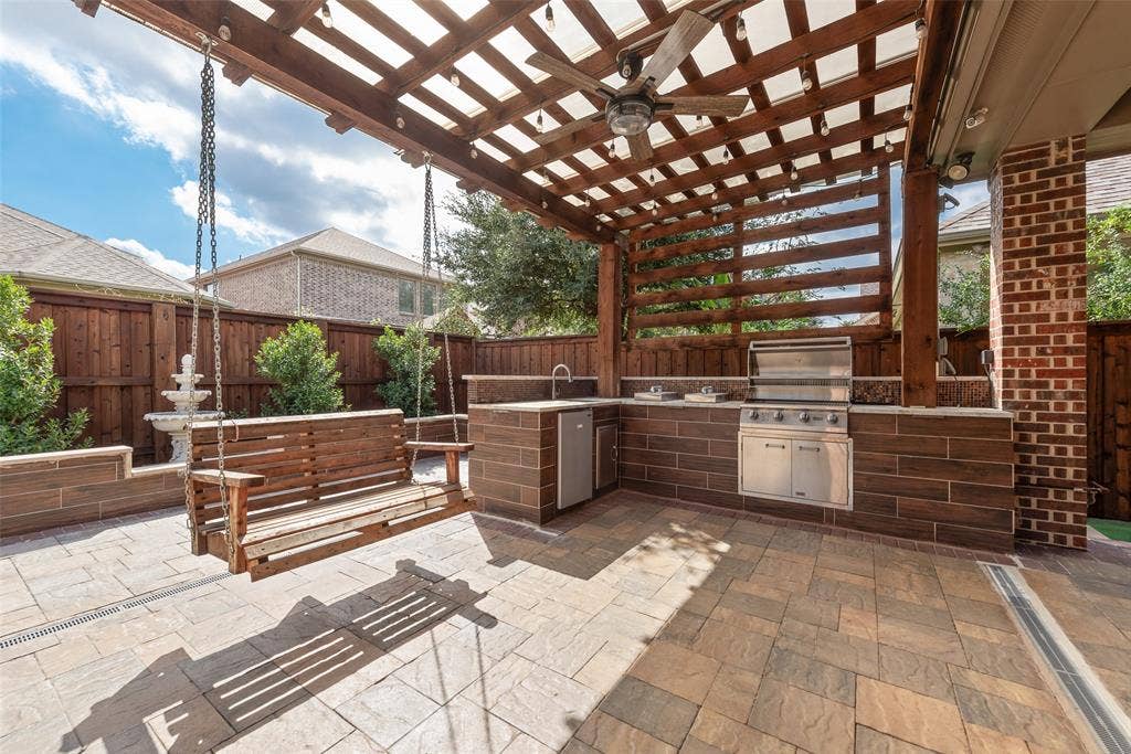 Awesome pergola-covered patio, expanded, with party lights & full kitchen, plus a relaxing swing.
