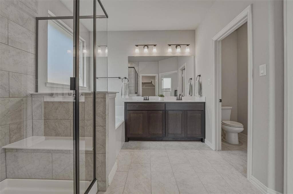Glass-enclosed shower with tiled walls and an integrated bench
