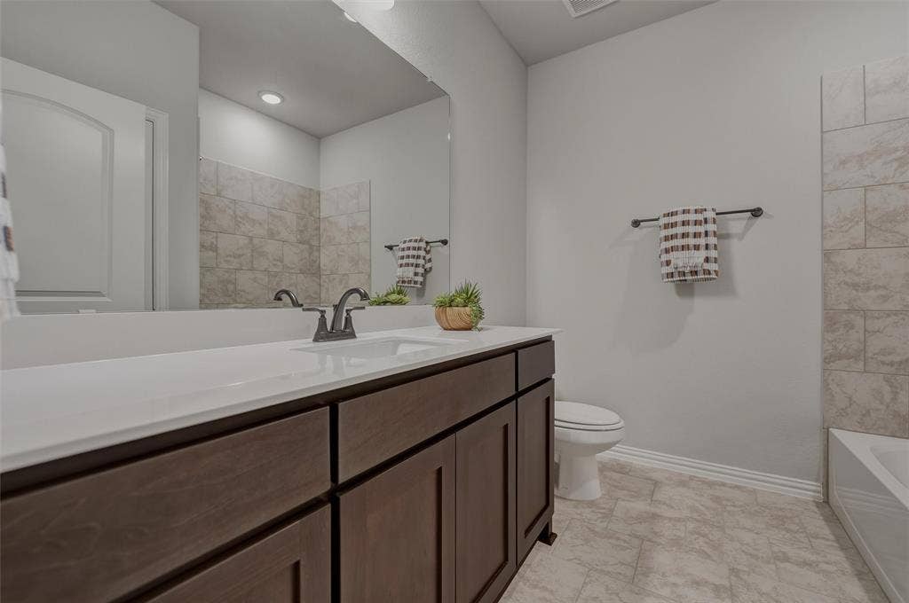 Wood-finish vanity with a white countertop and undermount sink