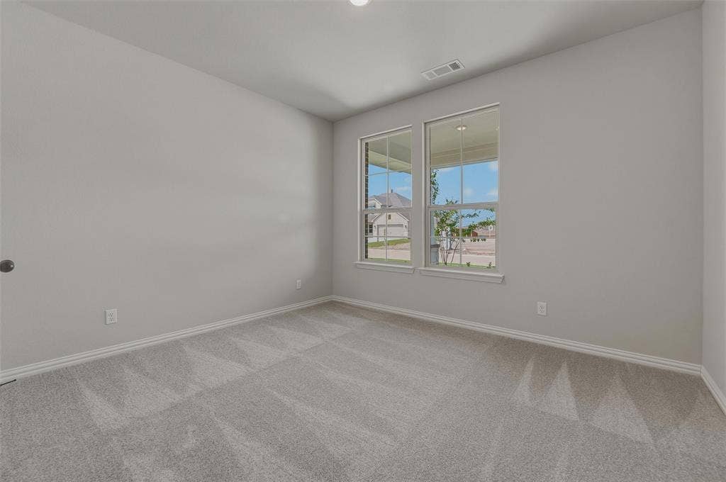 Light gray walls, patterned carpet flooring, and two double-hung windows