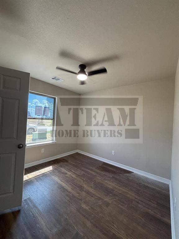 Room featuring wood-finish flooring, a neutral paint palette, a single-hung window, and a ceiling-mounted light fixture with fan blades