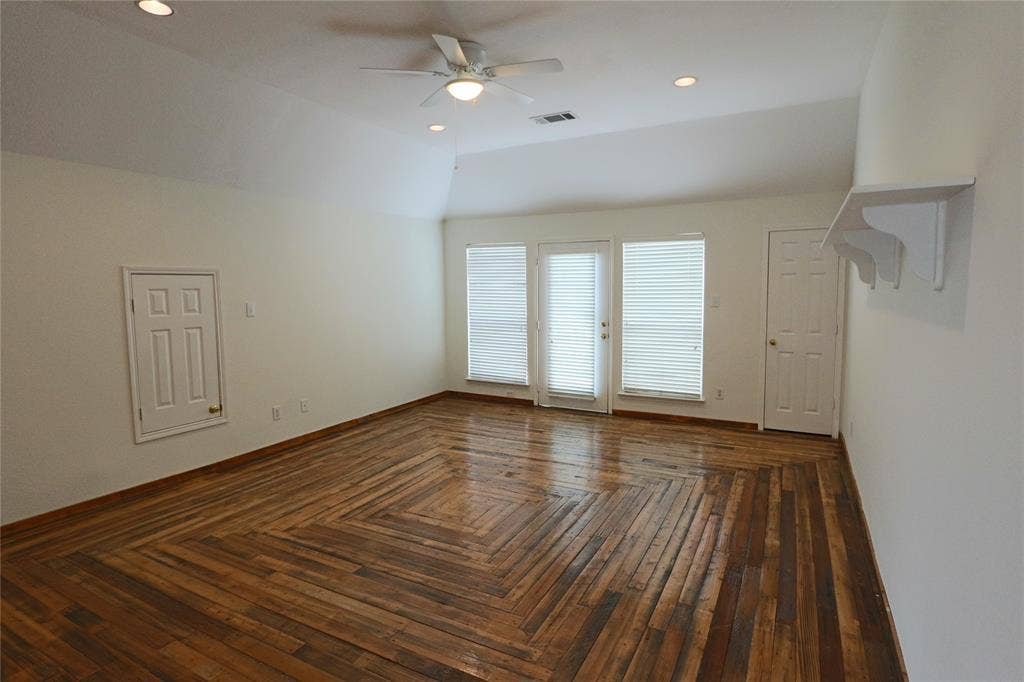 Game room with vaulted ceiling, decorate wood work floor, closet and entrance to the balcony.