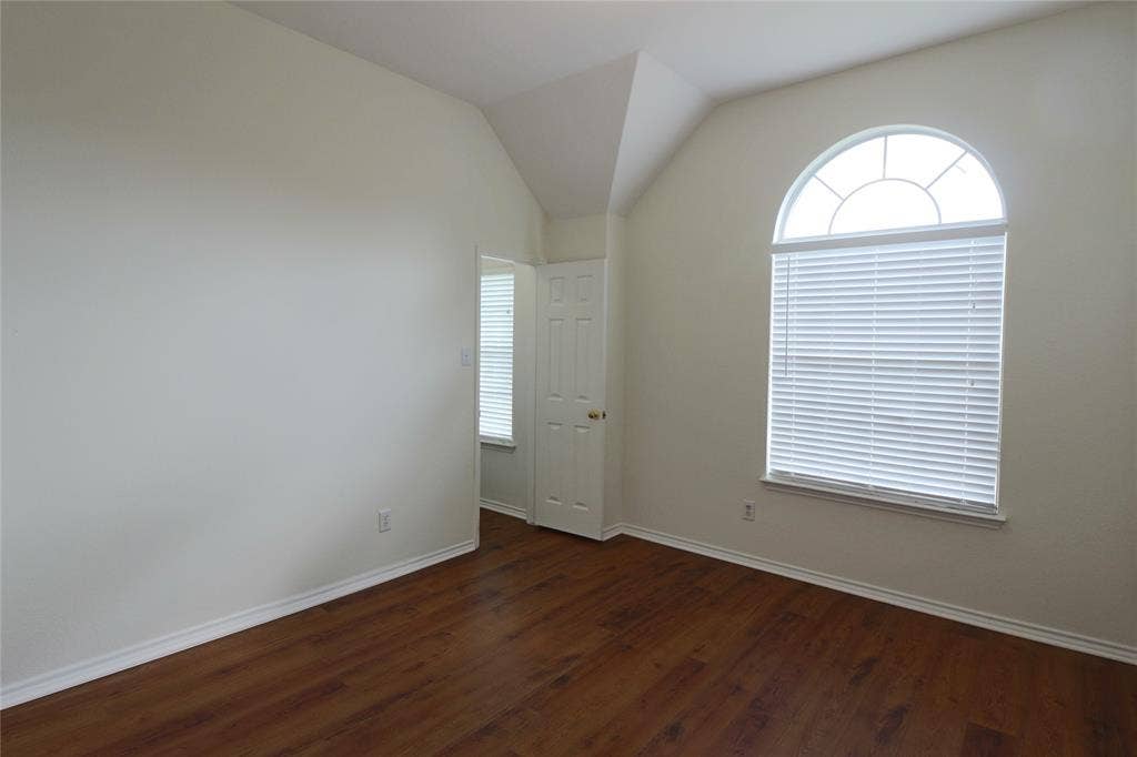 second bedroom with wood flooring, walk in closet and extra nook