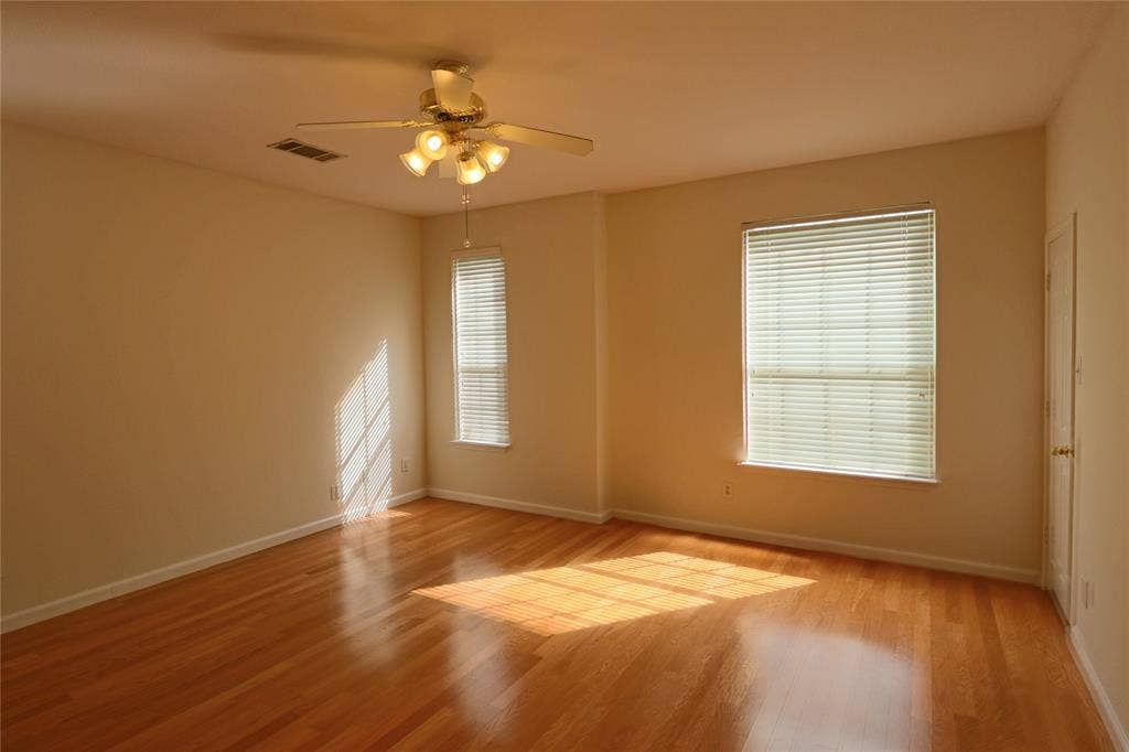 Primary bedroom featuring wood flooring, ceiling fan and second walking closet