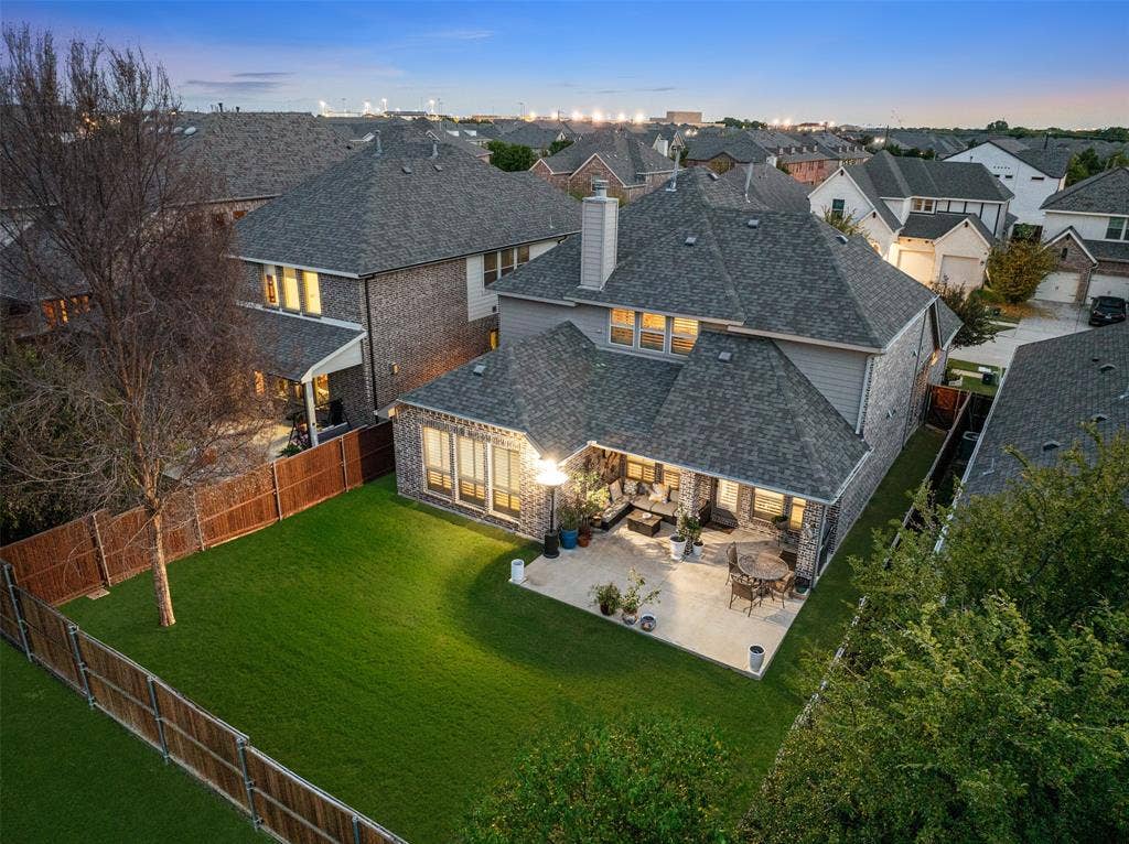 Backyard featuring a paved stone patio, fenced perimeter, and grass lawn