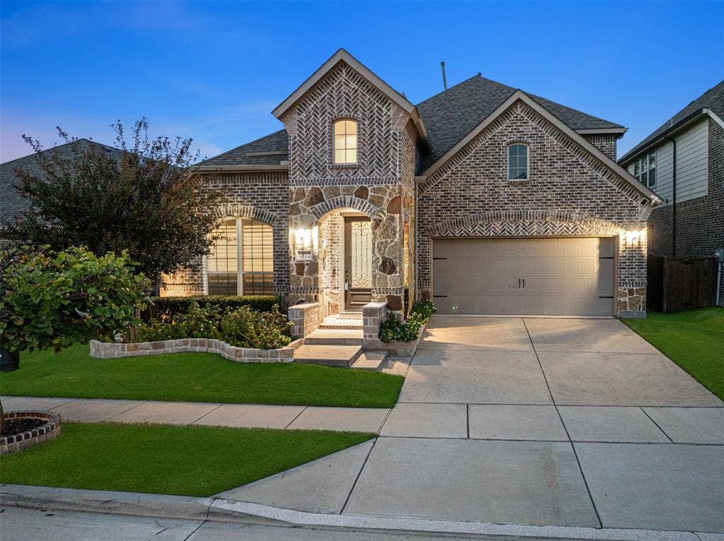 Brick and stone exterior featuring a herringbone masonry pattern, arched entryway, and multi-gabled roofline