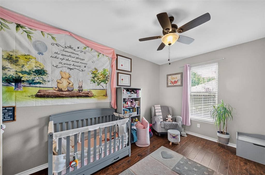 Wood-finish flooring, neutral wall paint, and a ceiling fan with integrated light fixture, complemented by a window with horizontal blinds