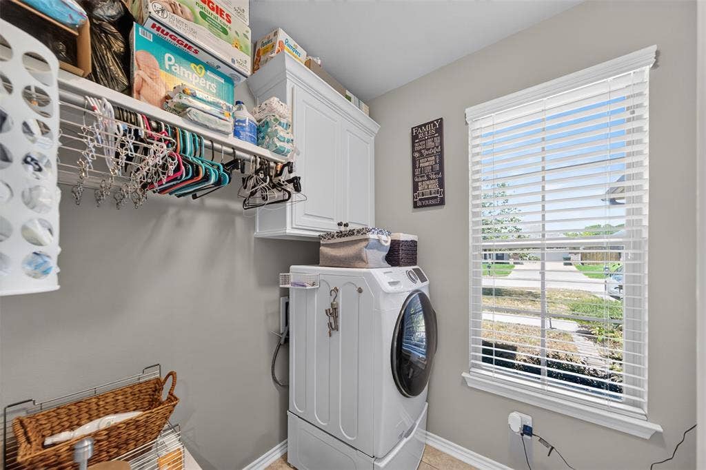 Utility area featuring built-in white cabinetry, integrated shelving, and a window with blinds