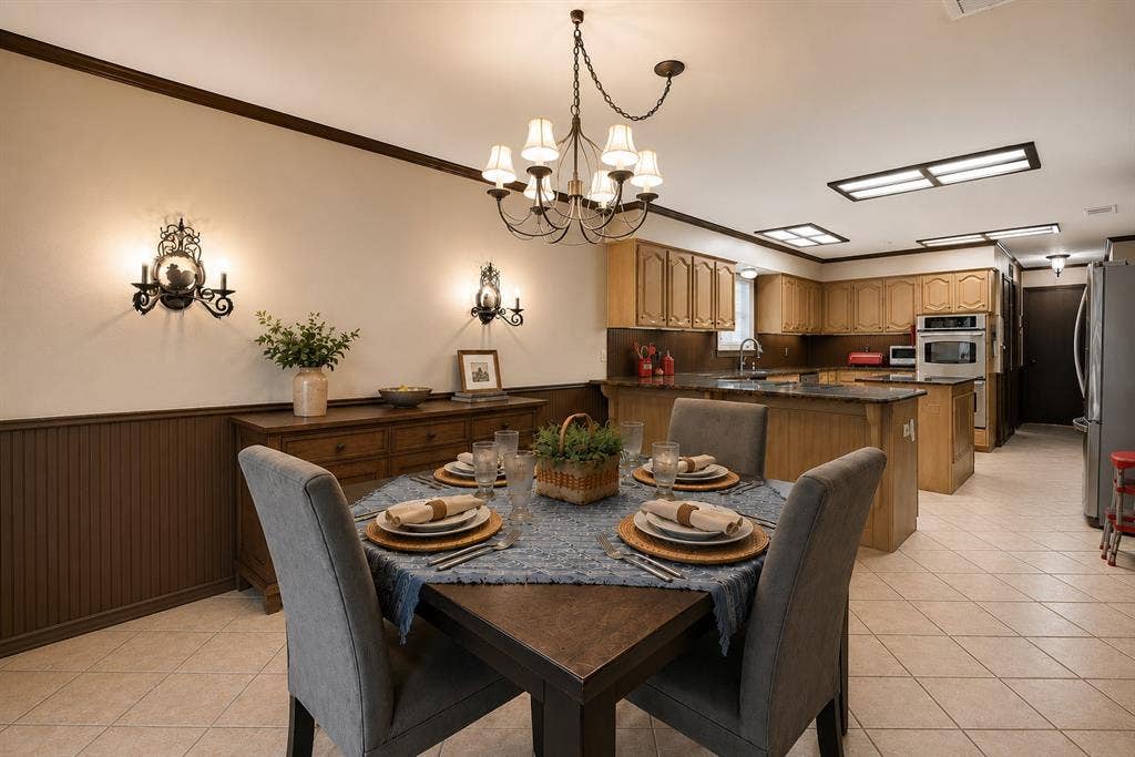 4008 Fairlakes Drive, Dallas, TX 75228 Dining area featuring a chandelier, wall sconces, and beadboard paneling
