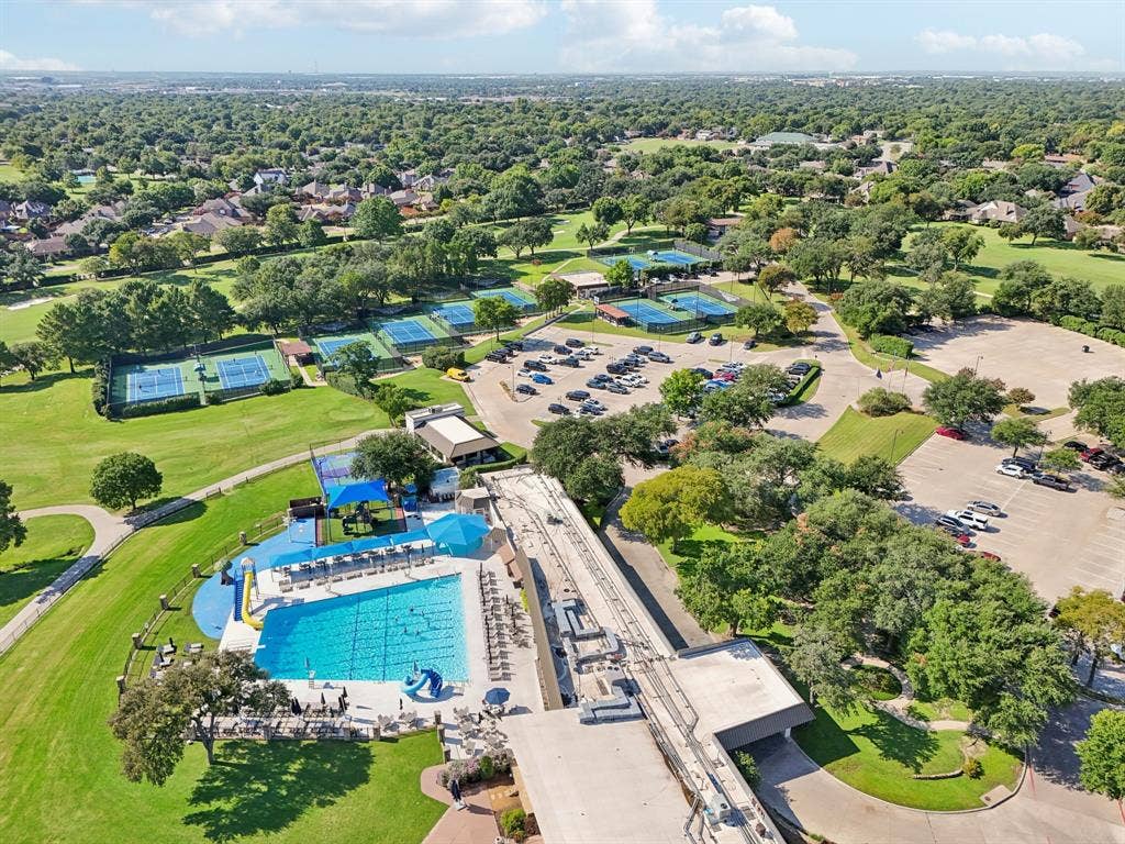 4008 Fairlakes Drive, Dallas, TX 75228 Aerial perspective showcasing extensive community amenities, including a large swimming pool, multiple tennis courts, and expansive parking areas