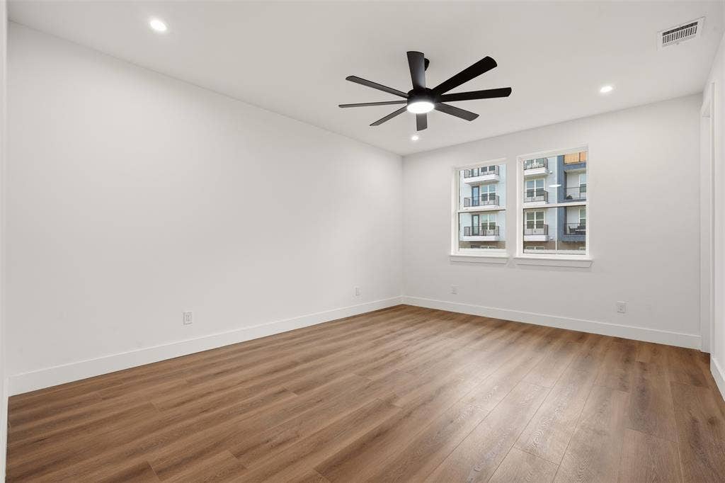Interior room featuring wood-finish flooring, recessed lighting, and a multi-blade ceiling fan with integrated lighting