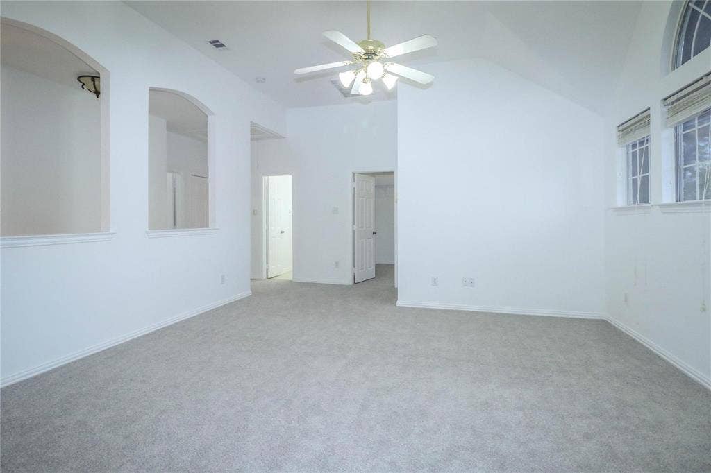 504 Renfro Court, Irving, TX 75063 Vaulted ceilings featuring recessed arch niches, carpeted flooring, and a multi-light ceiling fan