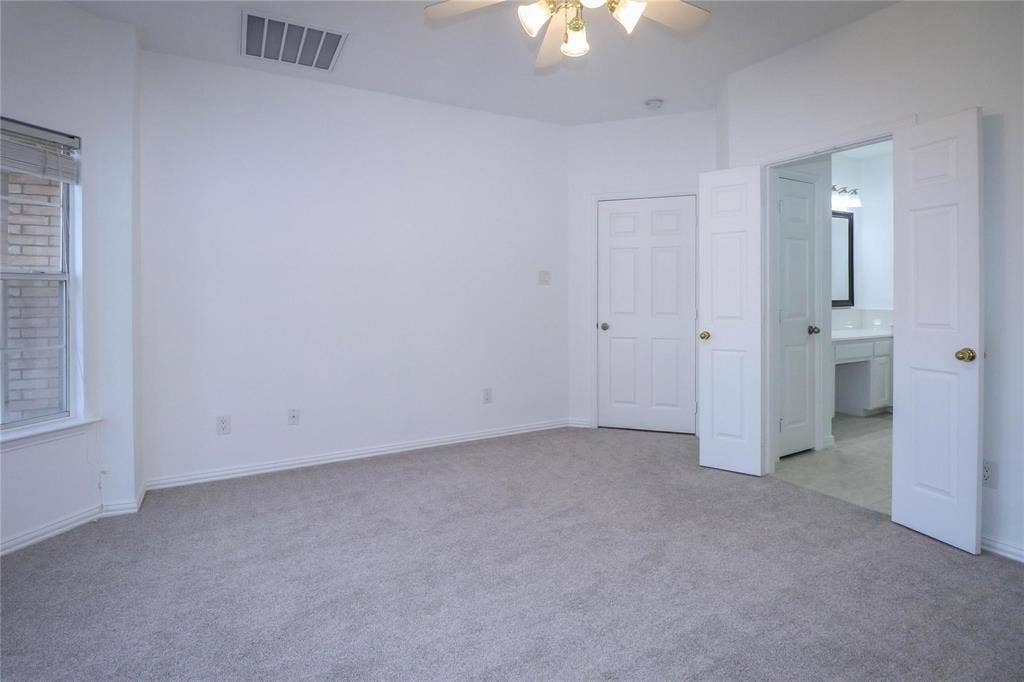 504 Renfro Court, Irving, TX 75063 Neutral-toned wall-to-wall carpeting, multi-pane window, ceiling fan with integrated lighting, and white six-panel interior doors
