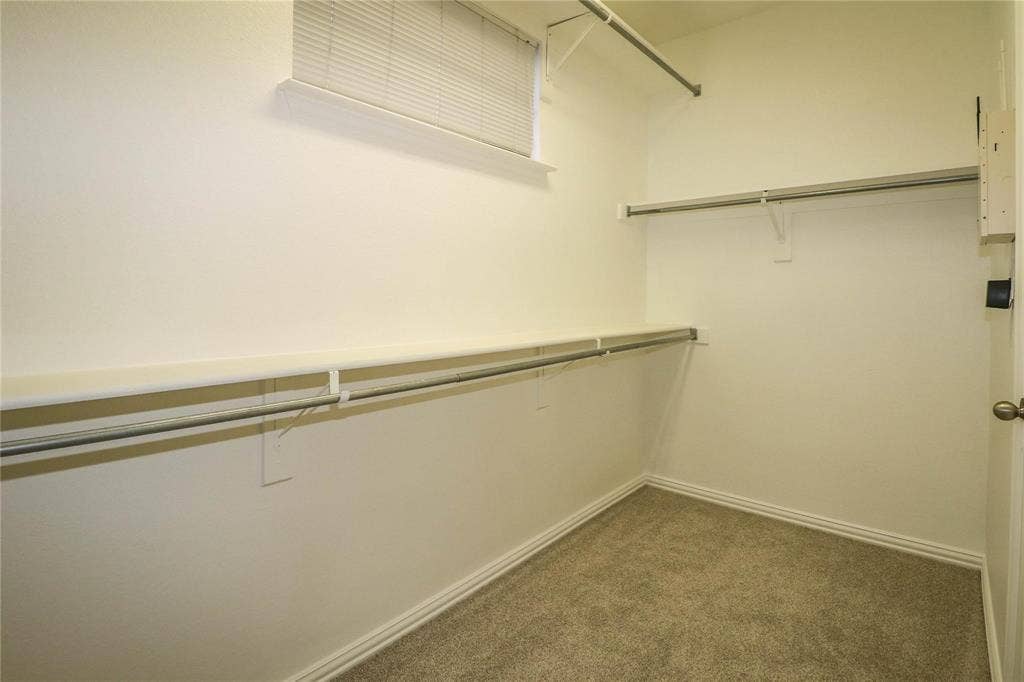 504 Renfro Court, Irving, TX 75063 Walk-in storage space featuring neutral carpeting, tiered shelving, and metal hanging rods