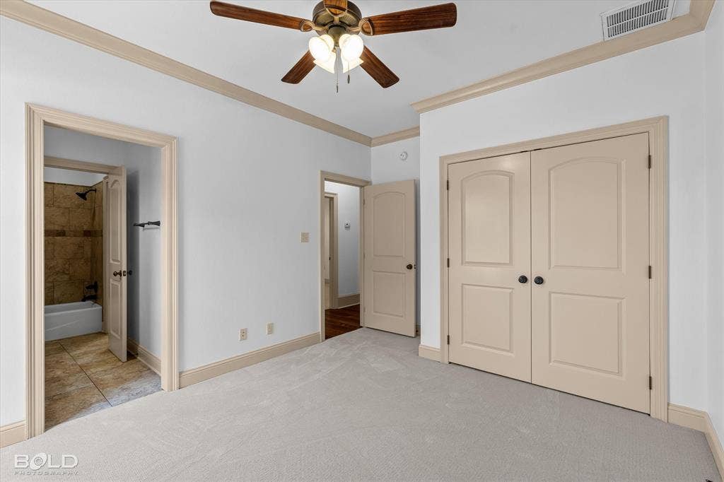 718 Duckwater Landing, Bossier City, LA 71111 Interior space featuring neutral wall-to-wall carpeting, crown molding, double-door closet, and a multi-light ceiling fan