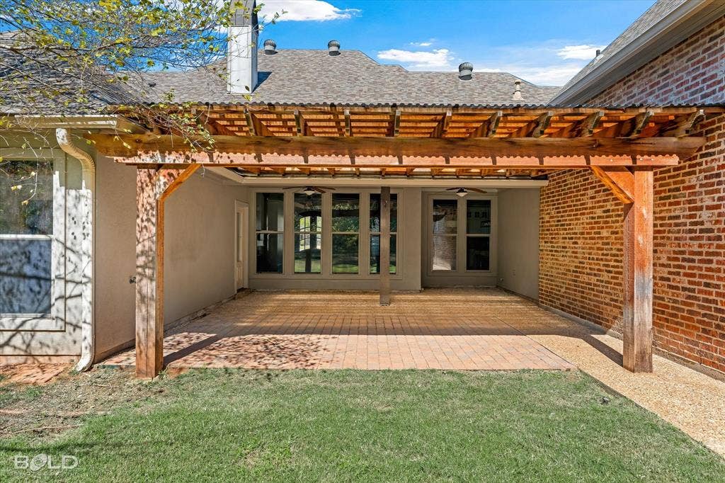 718 Duckwater Landing, Bossier City, LA 71111 Covered patio featuring a timber pergola, brick and stucco exterior, stone paver flooring, and built-in ceiling fans
