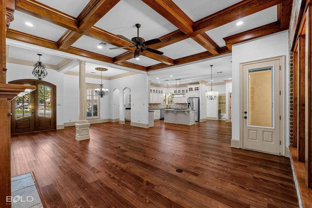 718 Duckwater Landing, Bossier City, LA 71111 Expansive open floor plan featuring coffered ceilings with exposed wood beams, wood-finish flooring, recessed lighting, and arched doorways