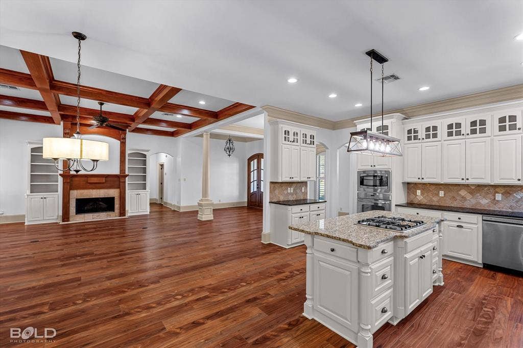 718 Duckwater Landing, Bossier City, LA 71111 Kitchen featuring shaker-style cabinetry, stone countertops, and a central island with a built-in gas cooktop