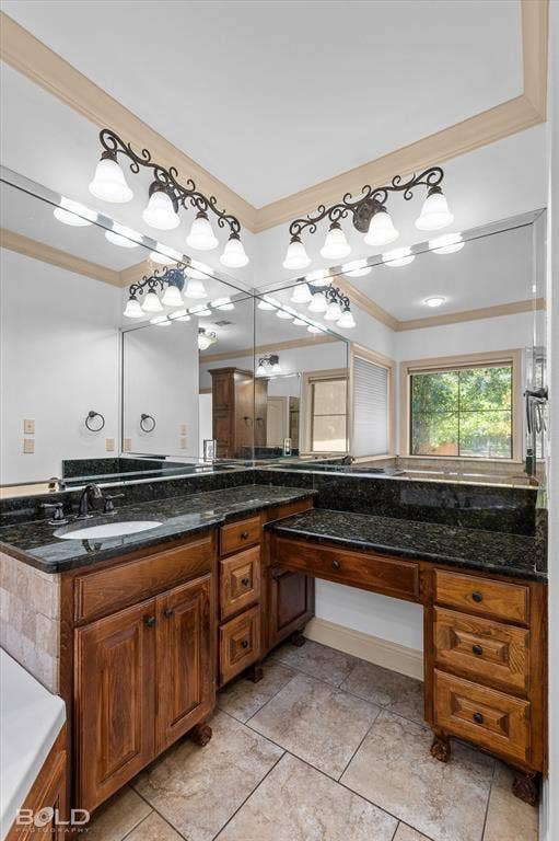 718 Duckwater Landing, Bossier City, LA 71111 Custom-built stained wood cabinetry with integrated vanity seating, dark stone countertop, undermount sink, multi-light decorative wall fixtures, and large-format tile flooring