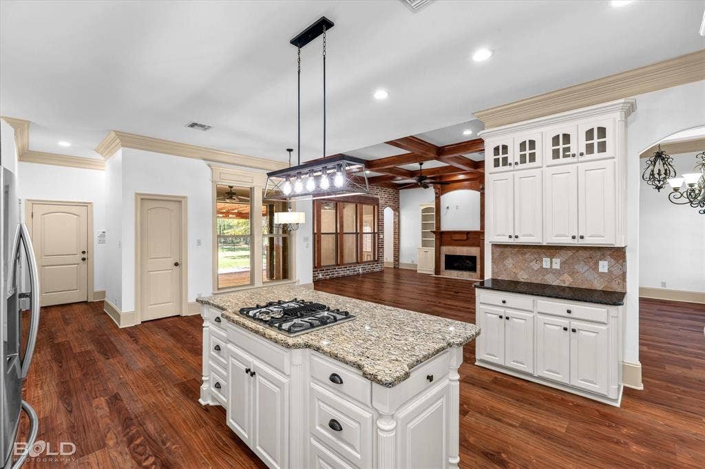 718 Duckwater Landing, Bossier City, LA 71111 Kitchen featuring a central island with a stone countertop and built-in gas cooktop, white cabinetry, wood-finish flooring, recessed lighting, and a multi-pendant light fixture