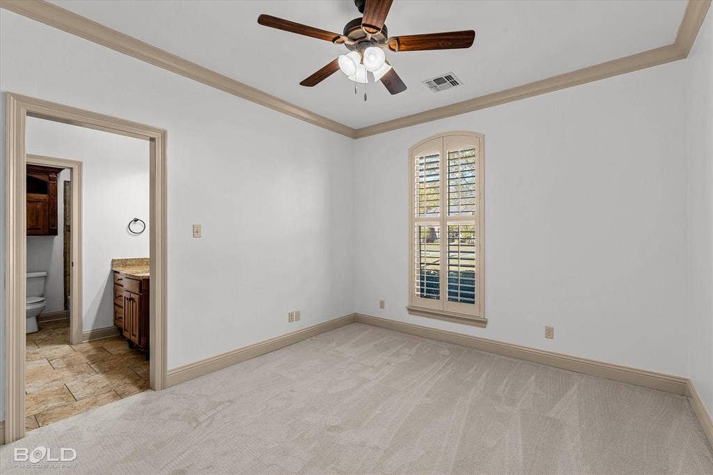718 Duckwater Landing, Bossier City, LA 71111 Neutral carpeting, ceiling fan with integrated lighting, arched window with plantation shutters, and crown molding