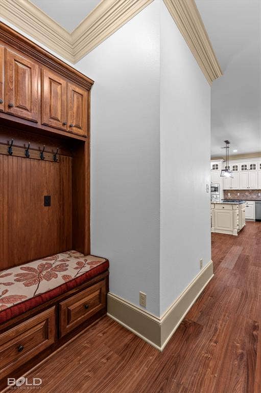 718 Duckwater Landing, Bossier City, LA 71111 Custom wood-finish cabinetry featuring an integrated bench seat and storage drawers, crown molding, and wood-finish flooring