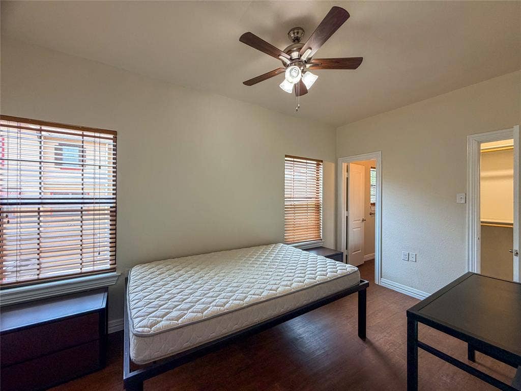 2410 S 2nd Street, #1373, Waco, TX 76706 BedRoom 3: featuring wood-finish flooring, two windows with blinds, and a ceiling fan with integrated lighting
