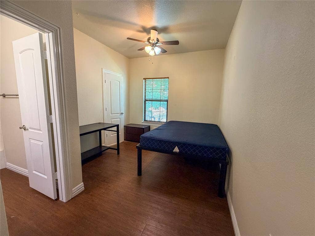 2410 S 2nd Street, #1373, Waco, TX 76706 Bedroom 4: featuring wood-finish flooring, a window with blinds, a ceiling fan with light fixture, and a white interior door